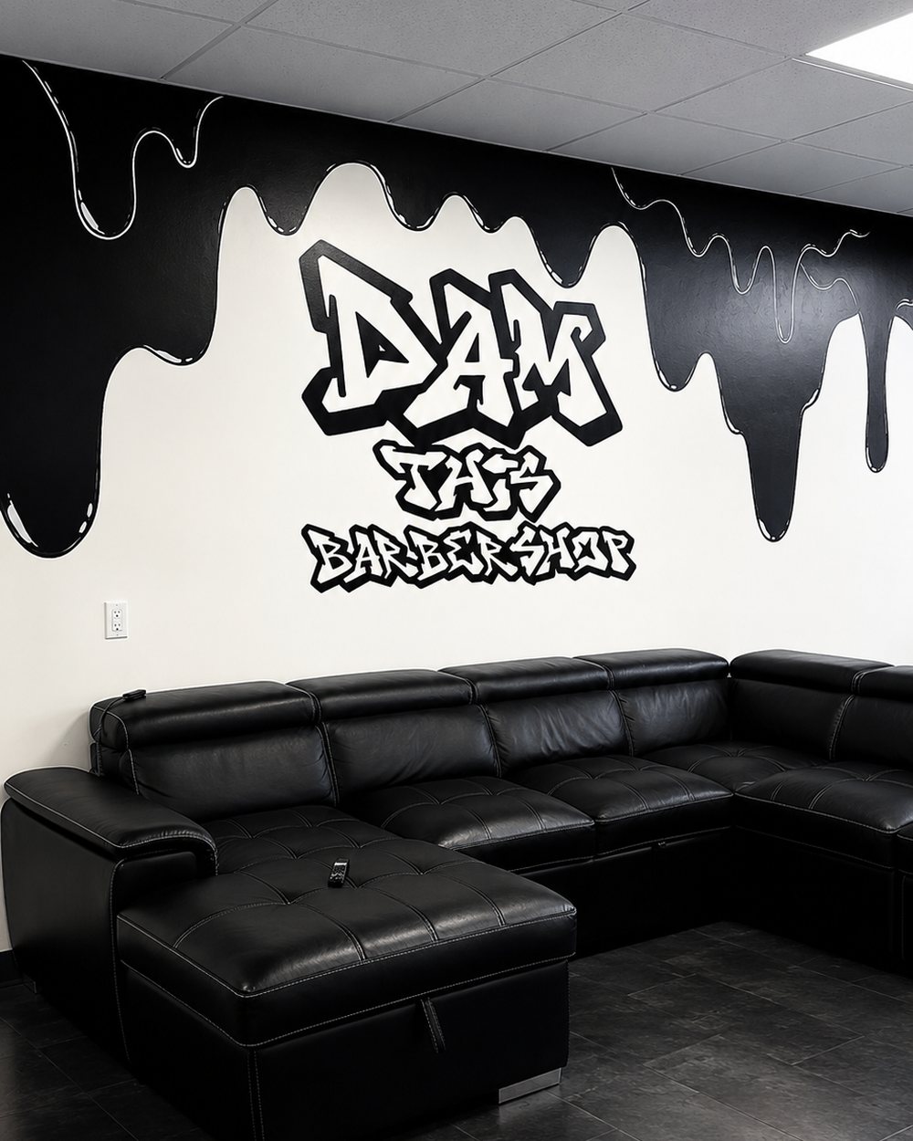 The Dam This Barbershop graffiti mural and drip wall above the lounge seating