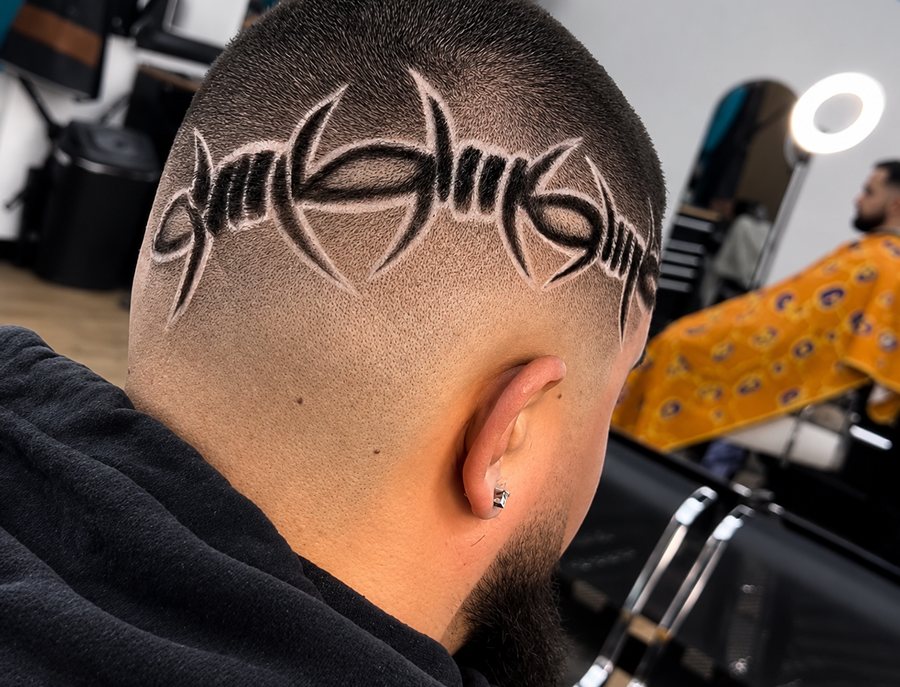 A freehand barbed-wire design carved into a skin fade